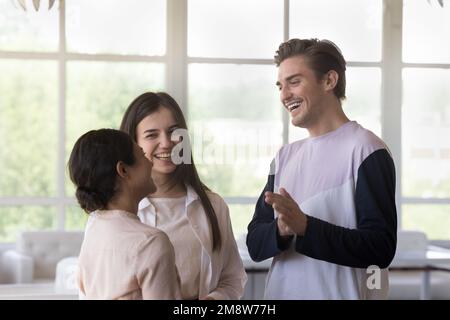 Multiethnische glückliche Freunde, die sich unterhalten und lachen, sich im Café treffen Stockfoto