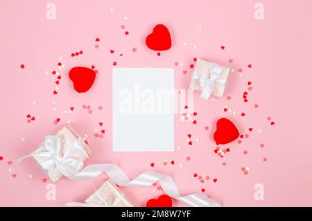 Leeres weißes Papier, leere Geschenkschachteln, viele Herzen auf hellrosa Hintergrund. Konzept des St. Valentinstag, Hochzeiten, Verlobungen, Muttertag, b Stockfoto