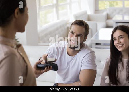 Ein fröhliches Paar von Gästen, die im Café Rechnungen bezahlen Stockfoto