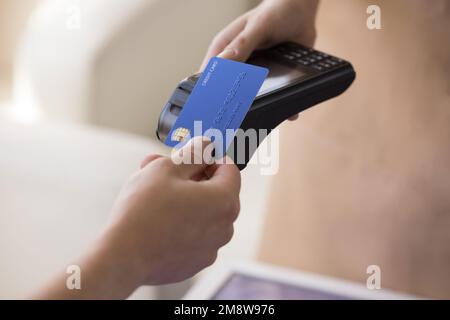 Die Hand des Karteninhabers, der die Rechnung im Café bezahlt Stockfoto