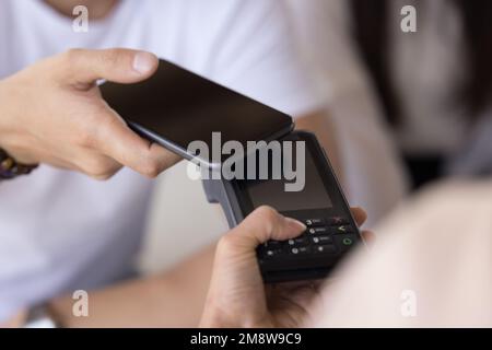 Männliches Smartphone, das die Kamera am Zahlungsterminal anbringt Stockfoto
