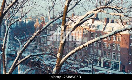 Romantischer und verschneiter Blick von oben auf die Prinsengracht im historischen Viertel De Jordaan, Amsterdam. Stockfoto