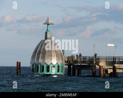 Die Tauchglocke ist bereit zum Tauchen am Pier in Zingst in Darß mit Strand und Küste im Hintergrund und den Wellen der Ostsee Stockfoto