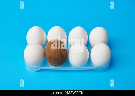 Haarige Kiwi zwischen glatten Eiern, Konzept der männlichen Enthaarung. Stockfoto