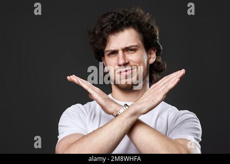 Junger, aufgebärdeter Mann, der Stopp-Gesten zeigt Stockfoto