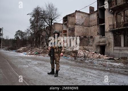 Lyman, Ukraine. 15. Januar 2023. Ein ukrainischer Soldat steht vor den Ruinen eines Wohngebäudes in der kürzlich befreiten Stadt Lyman.die Stadt Lyman, die vor 3 Monaten von den ukrainischen Streitkräften befreit wurde, ist Zeuge der Barbarei des Krieges. Häuser und Gebäude völlig zerstört und Zivilisten versuchen zu überleben. Kredit: SOPA Images Limited/Alamy Live News Stockfoto