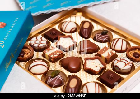 Zürich, Schweiz - Januar 7 2023: Lindt Mini Pralines Box. Nahaufnahme einer offenen kleinen Geschenkbox mit Süßigkeiten aus Schweizer Schokolade. Luxuriöse Auswahl an Milch, dunklen und weißen Miniatur-Meisterwerken. Stockfoto