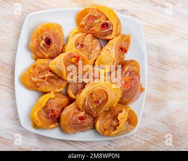 Bild von frischen, rohen Hähnchenschenkeln auf einer Holzfläche Stockfoto