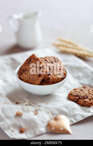 Hausgemachte Kekse mit Müsli und Samen, Schüssel auf einem Tisch, Seitenansicht Stockfoto