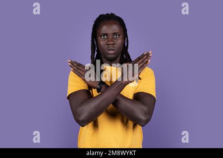 Ein seriöser afroamerikanischer Millennials, der "Nein" sagt, in die Kamera schaut und Hände über der Brust zeigt, blauer Studiohintergrund, Kopie Stockfoto