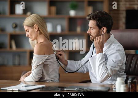 Männlicher Arzt Führt Medizinische Untersuchung Bis Zu Weiblichen Patienten In Der Klinik Stockfoto