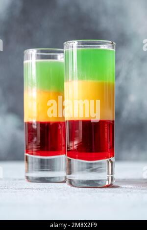 Mehrlagiger Squashed Frog Cocktail in Schnapsglas Stockfoto