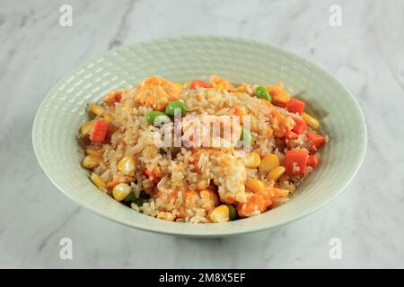 Authentischer chinesischer gebratener Reis aus Yangzhou mit Ei und Gemüse, isoliert auf einem Marmortisch Stockfoto