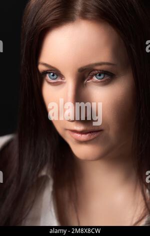 Porträt einer kaukasischen, erwachsenen Frau im Alter von 40 Jahren. Hübsches weibliches menschliches Gesicht von Brünette mit grauen Augen Stockfoto