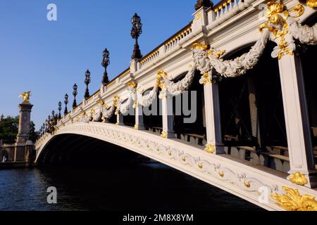 Paris: Brücke Pont Alexandre III über die seine, die kurz vor Sonnenuntergang in Paris, Frankreich, blendend weiß vor blauem Himmel blendet Stockfoto