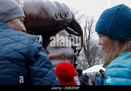 Boston, USA. 15. Januar 2023. Besucher besuchen die Skulptur „The Embrace“ des Künstlers Hank Willis Thomas am Boston Common am 15. Januar 2023 in Boston Massachusetts, USA. Die Skulptur erinnert an Martin Luther King Jr. und seine Frau Coretta Scott King, die nach einem Foto entworfen wurde, das 1964 von Dr. King nach Erhalt seines Friedensnobelpreises aufgenommen wurde. Kredit: SIPA USA/Alamy Live News Stockfoto