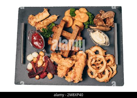 Snacks für Bier von Crackern, Zwiebelringen, Wurst, Käse und Sauce Stockfoto