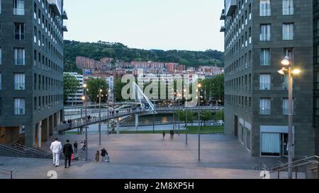 Architektonische Details der Innenstadt von Bilbao mit der Zubizuri-Fußgängerbrücke, die den Nervion überquert, im Hintergrund Stockfoto