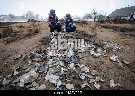 Nicht exklusiv: KOPYLIV, UKRAINE - 15. JANUAR 2023 - zwei Jungen sammeln die Fragmente einer russischen Rakete auf, Kopyliv, Region Kiew, Nordukraine. Stockfoto