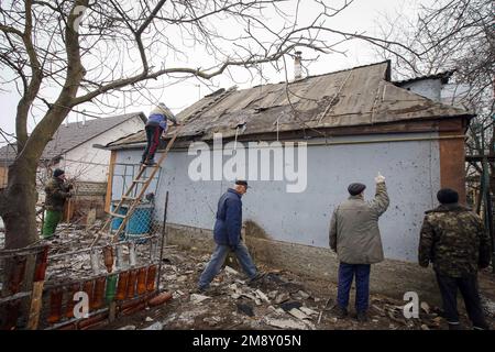 Nicht exklusiv: KOPYLIV, UKRAINE - 15. JANUAR 2023 - Männer bleiben außerhalb eines Hauses, das durch die Bombardierung durch russische Truppen beschädigt wurde, Kopyliv, Region Kiew, Nordbritisch Stockfoto