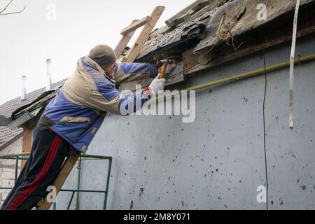 Nicht exklusiv: KOPYLIV, UKRAINE - 15. JANUAR 2023 - Ein Mann hämmert in einen Nagel, während er ein Haus repariert, das durch die russischen Truppen Kopyliv, Kyi, beschädigt wurde Stockfoto