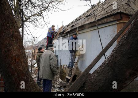 Nicht exklusiv: KOPYLIV, UKRAINE - 15. JANUAR 2023 - Männer reparieren ein Haus, das bei der Beschießung durch russische Truppen, Kopyliv, Kiew, Nordukraine beschädigt wurde. Stockfoto