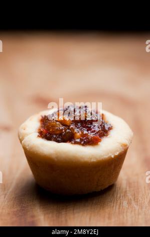 Eine einzige Obsttorte auf einer Holzbank zu Weihnachten Stockfoto