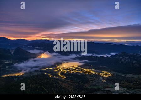 Sonnenaufgang im Vall de Lord Tal mit Nebel über dem Reservoir und rötlichen Wolken. Gesehen von Port del Comte (Solsonès, Lleida, Katalonien, Spanien) Stockfoto