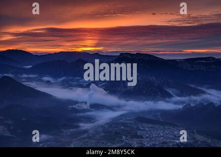 Sonnenaufgang im Vall de Lord Tal mit Nebel über dem Reservoir und rötlichen Wolken. Gesehen von Port del Comte (Solsonès, Lleida, Katalonien, Spanien) Stockfoto