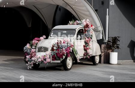 Minsk, Weißrussland, Januar 2023 - im Vintage Citroen-Auto dekorierte Blumen stehen auf der Straße Stockfoto