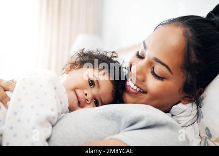 Das hätte ich mir nie träumen lassen. Eine junge Frau, die mit ihrem kleinen Mädchen kuschelt. Stockfoto