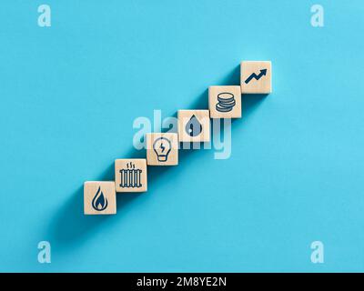 Steigende Energiepreise oder Energiekosten. Energiekrise und Inflationskonzept. Holzwürfel mit Gas-, Strom-, Öl-, Heizungs- und Geldsymbolen. Stockfoto