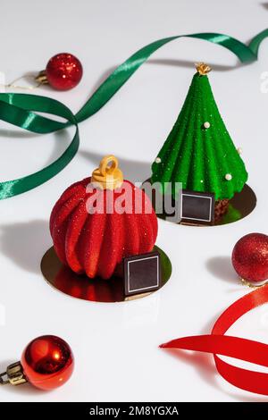 Gebäck in Form von rotem Weihnachtsball und grünem Baum Stockfoto