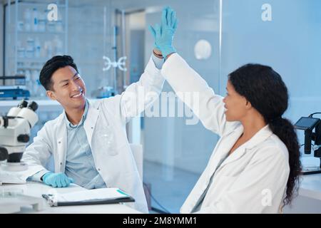 Die Besten der Besten. Zwei Labortechniker, die sich gegenseitig hochheben. Stockfoto
