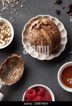 Schale mit Schokolade und Karamelleis auf grauem Hintergrund, Draufsicht Stockfoto