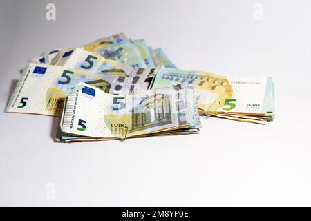 Fünf-Euro-Banknotenstapel, die von geringem Wert gesammelt werden, können zu einer Menge Geld werden, ein Konzept für Unternehmen, Finanzen oder Inflation, hellgrauer Hintergrund, Kopie Stockfoto