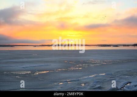 Sonnenaufgang über dem Meer an einem wunderschönen Vormittag Mitte März, mit dem Meer nur noch teilweise eisbedeckt. Der Frühling gewinnt, und die Zugvögel kommen Stockfoto