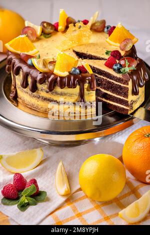 Schokoladenkuchen mit Zitruscreme, Ganache, Orangen, Zitrone und Beeren Stockfoto