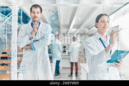Wissenschaft ist das Studium von Fakten. Zwei junge Wissenschaftler, die in einem Labor mit Notizen auf einem Glasbildschirm Brainstorming machen. Stockfoto