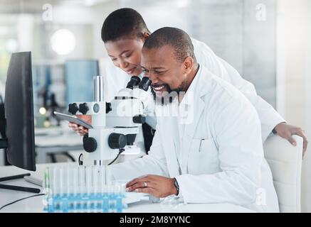 Man muss exakt sein mit seinen Maßen. Zwei Wissenschaftler verwenden Mikroskope in einem Labor. Stockfoto