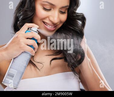 Dieses Produkt bietet einen besonders starken Halt. Eine Frau, die ihr Haarspray auf die Haare legt. Stockfoto