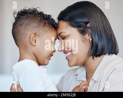 Süßer kleiner Junge und mom, die die Stirn berühren. Nahaufnahme von glücklicher Mutter und Sohn, die sich gegenseitig in die Augen schauen. Gemischte Familie, die Liebe ausdrückt und Stockfoto