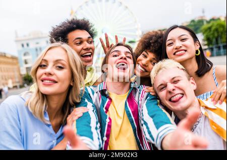 Multirassische junge Menschen treffen sich und treffen sich - Gruppe von Freunden mit gemischten Rassen, die Spaß im Freien in der Stadt haben - Freundschaft und Lif Stockfoto