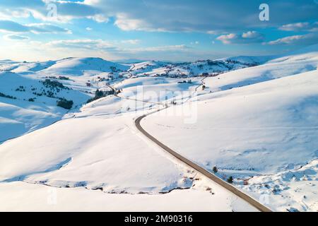 Luftaufnahme von leerer Straße und gefrorenem Bergbach in der Winterlandschaft in Zlatibor, Serbien Stockfoto