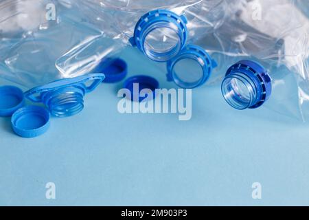 Viele leere Plastikflaschen auf blauem Hintergrund. Abfall- und Verschmutzungskonzept. Stockfoto