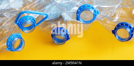 Viele leere, verdorbene Flaschen aus Plastik auf gelbem Hintergrund. Abfall- und Verschmutzungskonzept. Banner Stockfoto