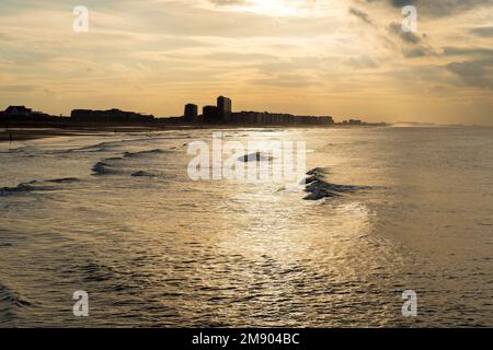 Nordseewellen bei Sonnenuntergang mit Oostende (Ostende) Strand und Skyline, Westflandern, Belgien. Stockfoto