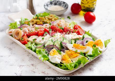 Gesunder cobb-Salat mit Schinken, Gurken, Tomaten, Oliven, Fetakäse und Eiern. Ketogenes Mittagessen. Stockfoto