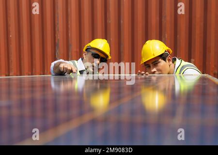 asiatische Universitätsstudentin lernt alternative nachhaltige Energie und baut Solarpaneele mit Professor auf. Ingenieurteam arbeitet an Überprüfung und Wartung Stockfoto