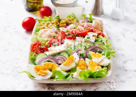 Gesunder cobb-Salat mit Schinken, Gurken, Tomaten, Oliven, Fetakäse und Eiern. Ketogenes Mittagessen. Stockfoto